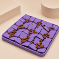 Purple Licki slow feeder mat with kibble on a beige studio background